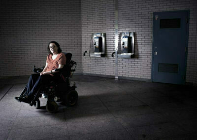 Une femme en fauteuil roulant devant deux téléphones publics qui lévitent